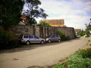 Ansicht von Nordosten mit Kirchhofmauer (Wehrgang mit Steinbrüstung im 18 Jh abgetragen) über Ortsseite