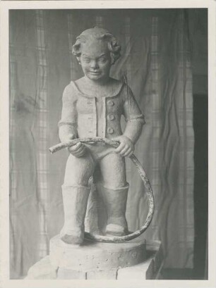Knabe in Stiefeln mit Wasserschlauch: Tonmodell auf Sockel: in Atelier, hinten Vorhang;
