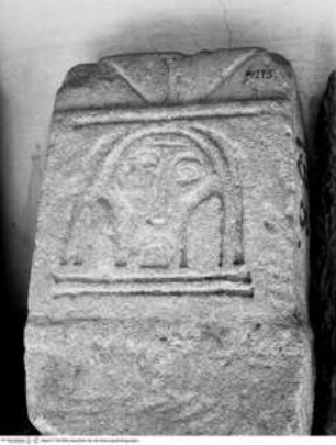 Prähistorischer Reliefstein mit Darstellung eines männlichen Kopfes