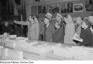 Ausstellungsbesucher während der Erklärung des Architekturmodells der Stalinallee in Berlin