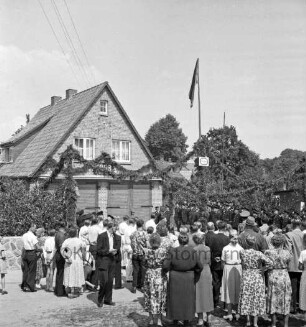 Lütjensee: Amtsfeuerwehrfest: Einweihung des Feuerwehrgerätehauses der Freiwilligen Feuerwehr Lütjensee: hinten Mitte Wehrführer: vorn Zuschauer und Gäste: hinten links mit Girlanden geschmücktes Gebäude: hinten rechts angetretene Wehren