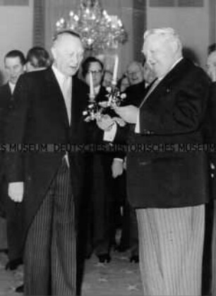 Ludwig Erhard überreicht Konrad Adenauer das Geburtstagsgeschenk des Kabinetts