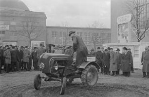 Ein Messebesucher testet auf dem Außengelände einen Allgaier-Porsche-Diesel-Schlepper der Firma Porsche-Diesel-Motorenbau GmbH