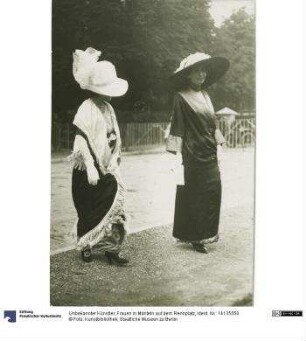 Frauen in Mänteln auf dem Rennplatz