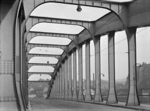 Aussig (heute Ústí nad Labem). Straßenbrücke (genietete Stahlbogenbrücke) über die Elbe. Blick von der Fahrbahn in Längsrichtung