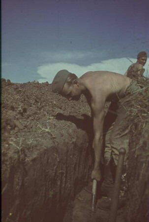 Zweiter Weltkrieg. Frontbilder. Der Fotograf Franz Gasser als Soldat der Deutschen Wehrmacht beim Ausheben eines Schützengrabens