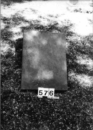 Grabstein 576 (Index: 99630078) Material: Sandstein Zustand: leicht verwittert Maße HxBxT: 34x34x10 cm Beschreibung: pultartige Stele, Sockel: Grabstein 576