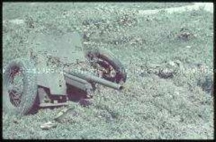 Getöteter Schütze neben einer Panzerabwehrkanone