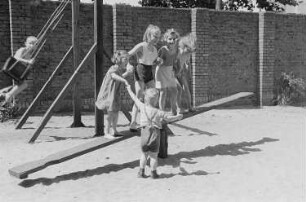 Betriebskindergarten der VEB Stralauer Glaswerke : Kinder auf einem Spielplatz auf einer Wippe
