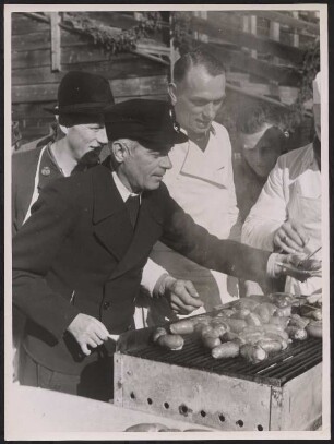 Reichssportführer Hans von Tschammer und Osten beim Ausgeben einer gegrillten Wurst