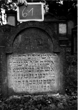 Grabstein 61 (Index: 100111128) Material: Sandstein Zustand: leicht verwittert Maße HxBxT: 75x63x17 cm Beschreibung: Stele, eingezogener Rundbogenabschluß, Schriftfeld eingetieft: Grabstein 61