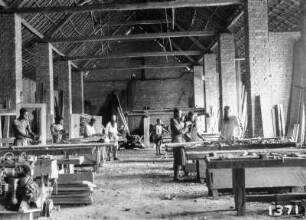 Holzwerkstatt : Eine Halle mit Arbeitern, die Holz bearbeiten.