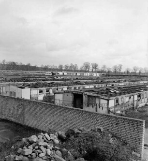 Heinrichshof, Gut: stillgelegte Schweinemastanlage: verfallene Schweineställe: im Vordergrund Mauer und Schutthaufen