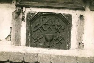 Bahnhofstr. 16: Steintafel, Hauszeichen der Maurer und Steinmetze, 1702