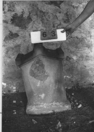 Grabstein 63 (Index: 100105866) Material: Sandstein Zustand: vollkommen verwittert Maße HxBxT: 78x49x23 cm Beschreibung: Stele, profilierter Sockel, Giebel mit Akroteren: Grabstein 63
