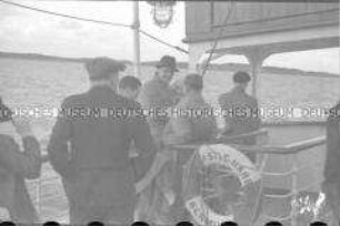 Passagiere des Hochseepassagierdampfers "Columbus" an Deck eines Zubringerbootes, Rettungsring mit der Aufschrift "Castle Harbour Bermuda", Ausflug an Land