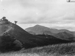 Landschaft : Blick von einer Anhöhe in ein Tal und auf bergige Umgebung