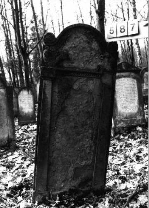 Grabstein 587 (Index: 99753084) Material: Sandstein Zustand: abgeblättert m. fast völl. Textverlust Maße HxBxT: 140x57x10 cm Beschreibung: ädikulaart. Stele m. Pilastern, in Voluten auslaufender Segmentbogenabschluß Symbolik: Trauben, Löwenpaar, Ranken, Voluten, Zahnfries, Zopffries: Grabstein 587