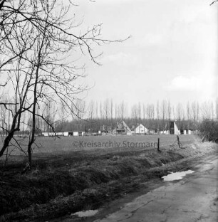Tremsbüttel-Dorf: Schloßstraße: Straßengraben, Zaun: Koppel: im Hintergrund Neubaugebiet Kiebitzmoor