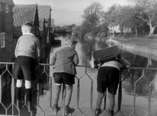 Otterndorf. Niedersachsen. Kinder auf dem Schulweg. Sie schauen von einer Brücke auf die Medem