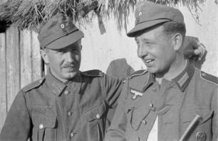 Zweiter Weltkrieg. Zur Einquartierung. Sowjetunion. Zwei Angehörige der deutschen Wehrmacht vor einer Bauernhütte