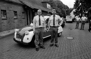 Polizeistation Großhansdorf: Verabschiedung des Polizeihauptmeisters Emil Vogt in den Ruhestand: Vogt mit Stationsleiter Karsten Witt vor einem 2CV als Polizeiwagen: rechts hinten Polizisten: links hinten Polizeigebäude: hinten Fahrzeuge und Wohnhaus: 28. Juni 2000