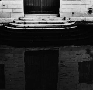 Venedig. Architekturdetail Treppenstufen eines Gebäudes, gespiegelt im Wasser