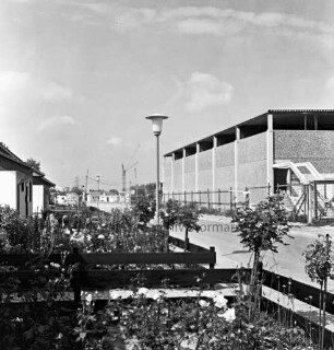 Sporteinrichtungen: Soltausredder: rechts Sporthalle: links Reihenhäuser mit Vorgärten und Zäunen: in der Mitte Straßenlampe: im Hintergrund Baukräne und Gebäude