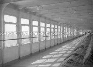 Fenster- und Liegestuhlreihe auf dem Promenadendeck der I. Klasse des Hochseepassagierdampfers "Bremen", Schattenspiel