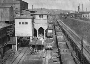 Blick auf den geöffneten beschrankten Bahnübergang Schachtstraße über die Döhlener Kohlenwäsche. Oben die DW-Linie. Unten verläuft als dritte Schiene im DWIR-Gleis (Dresden-Werdau Industriegleis Rechts) das PHV-Verbindungsleis nach Richtung Potschappel. Freitaler Revier, Kohlenwäsche