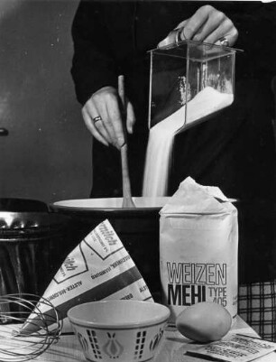 Kuchen backen. Die Zutaten werden in eine Schüssel geschüttet und mit der Hand verrührt