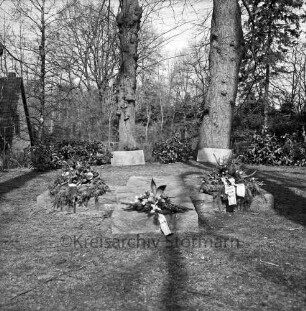 Eiskellerberg: Ehrenmal mit Gedenksteinen: darauf Kränze und Blumenschmuck: dahinter Sträucher und Bäume
