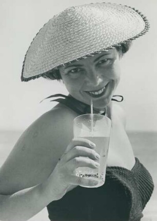 Model Helga am Strand der Ostsee. Ein kühler Drink tut bei der Hitze gut.