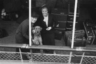 Bordleben. Passagiere mit Terrier und Reisegepäck auf dem Promenadendeck eines Passagierschiffes