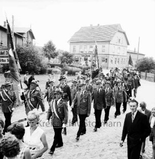 Schützenfest: Schützenverein Sprenge und Umgebung e.V.: Festumzug mit Fahnenabteilungen: vorn Zuschauer: im Hintergrund Bauernhäuser