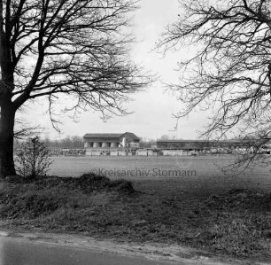 Heinrichshof, Gut: Blick über die Ländereien auf die stillgelegte Schweinemastanlage mit Futtermittelgebäude: vorn Böschung mit Bäumen