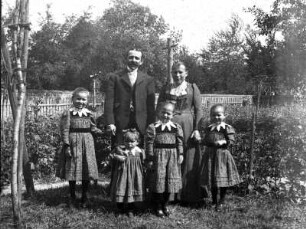 Eltern mit ihren vier Töchtern, aufgenommen in einem Garten in Coswig