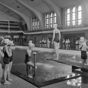 Frauen im Schwimmbad und auf dem Sprungbrett