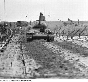 Deutschland . Nationale Volksarmee - Landstreitkräfte. Taktische Übung der Pioniertruppen. Kampfpanzer in Fahrt auf einer Pontonbrücke