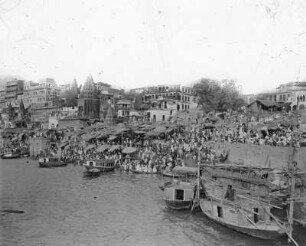 Varanasi (Benares), Indien. Stadtteilansicht mit Tempelanlagen. Blick vom Ganges zum Ufer mit Gläubigen