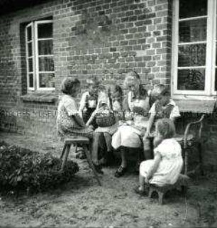 Arbeitsmaid des Reichsarbeitsdienstes bei Handarbeit und Kinderbetreuung