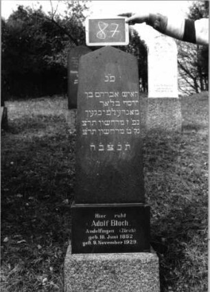 Grabstein 87 (Index: 100090238) Material: Granit Zustand: gut Maße HxBxT: 149x37x15 cm Beschreibung: konische Stele, Doppelsockel, giebelartiger Abschluß Steinmetz: Matt: Grabstein 87