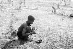 Expeditionsteilnehmer beim Kartoffelschälen : Aufnahme eines Jungen beim Schälen von Kartoffeln