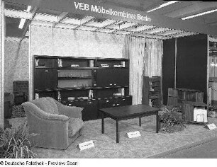 Ausstellungskoje mit Wohnzimmermöbeln des VEB Möbelkombinat Berlin. Ansicht mit Sessel aus der Sitzgruppe "Parat 83" und Klubtisch (Modell C 18)