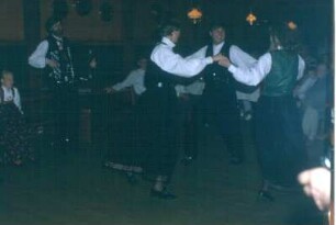 Norwegische Folkloregruppe mit Tanzpaaren und Akkordeonspieler