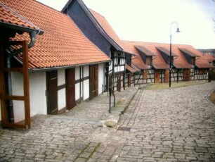 Evangelische Pfarrkirche - Kirchhof im Nordwesten nach Norden mit (rekonstruierten) Gaden (Fachwerk auf steinernem Stock - Kirchhofmauer als Außenmauer) in Übersicht