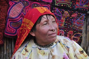 Kuna Yala - Kuna-Indianerin mit Mola-Kunstwerken : Porträtfoto einer Kuna-Indianerin vor ihren selbstgefertigten textilen Mola-Kunstwerken. Aufgenommen am 12. September 2011 auf einer der San Blas Inseln im autonomen Gebiet der Kuna-Indianer vor der Atlantikküste der Republik Panama