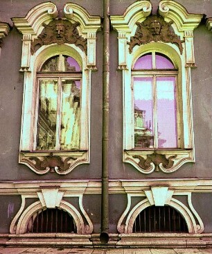 Verzierte Fenster einer Hausfassade mit Spiegelung
