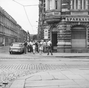 Warteschlange und Standposten der VP mit Maschinengewehr vor der Zweigstelle der Stadtsparkasse Dresden, Bischofsweg 18