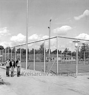 Sporteinrichtungen: Sportanlage am Kortenkamp: Kleinspielfeld nach Fertigstellung: links drei Schüler: dahinter Arbeiter an Maschendrahtzaun beim Setzen eines Steines: daneben Schubkarre: hinten rechts Sportlerheim: hinten links Wohnhäuser: dahinter Bäume